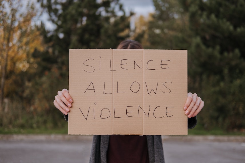 Girl Holding Sign That Reads Silence Allows Violence