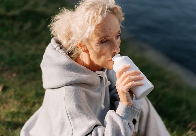 Woman Drinking Water After Taking Antibiotic Medicine