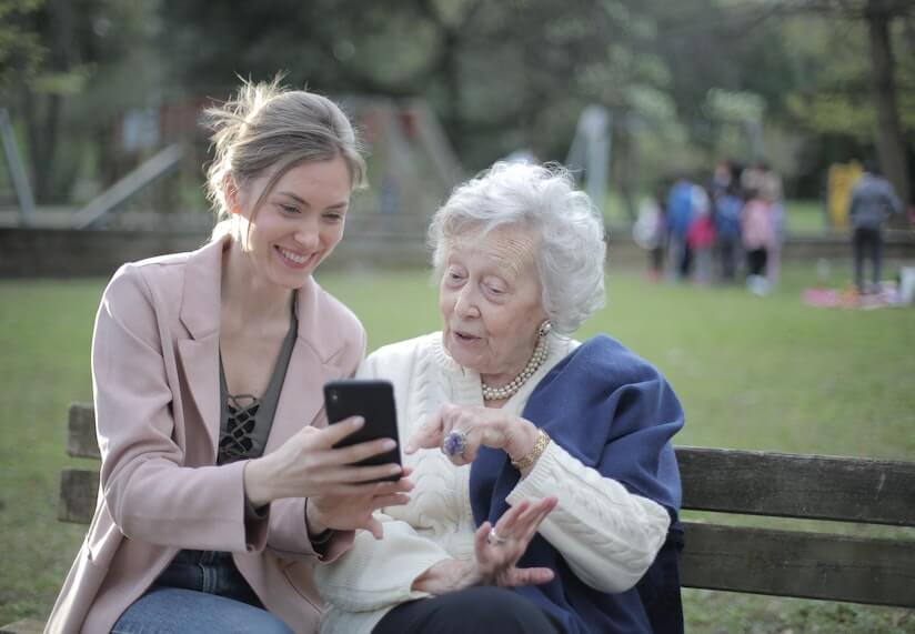 Young Woman Helping a Senior Lady with her Cellphone